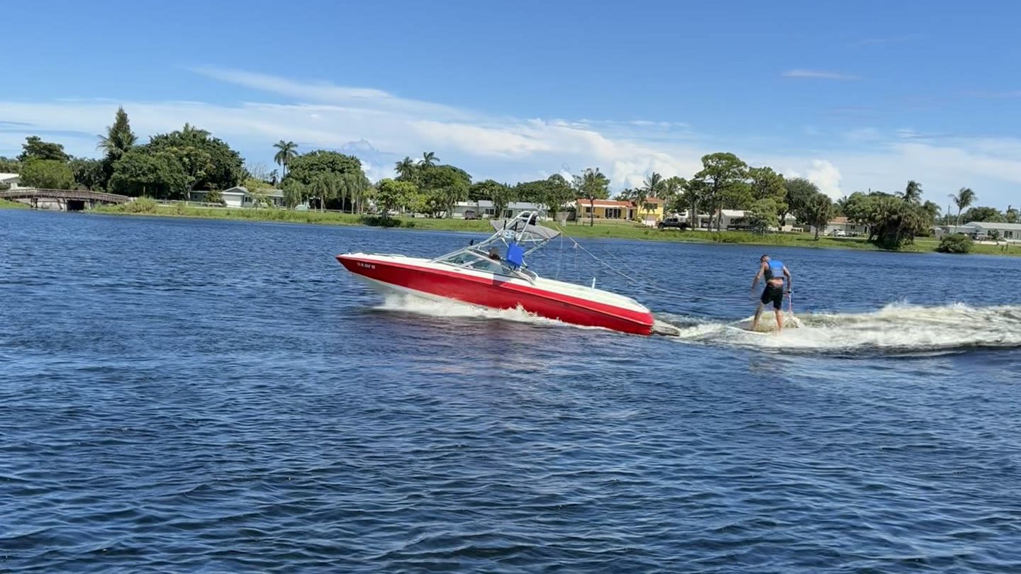 Wakesurfer riding behind an inboard wake boat on a South Florida lake